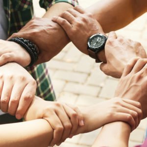 Close-up image of people holding each others wrists